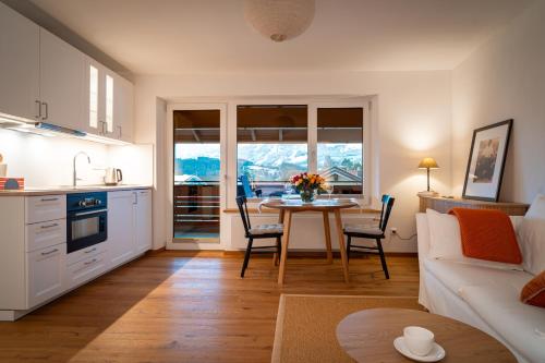 a kitchen and living room with a table and a couch at M8 Apartment - Zentral und exklusiv auf 290 m2 in Sonthofen