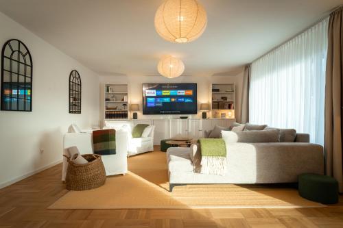 a living room with a couch and a tv at M8 Apartment - Zentral und exklusiv auf 290 m2 in Sonthofen
