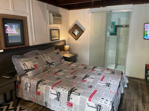 a bedroom with a bed with a comforter on it at Alemao Cabanas in Camburi