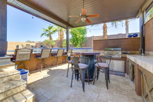 a patio with a table and chairs and a kitchen at Swim-Up Bar and Putting Green Goodyear Getaway! in Goodyear