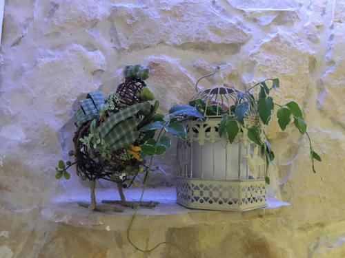 a bird statue sitting next to a plant in a basket at Casa di Lavanda in Hvar