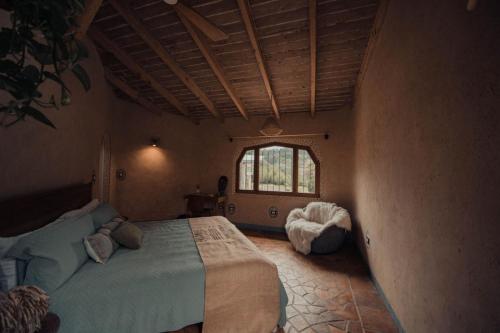 a bedroom with a bed in a room with a window at El EQUIMITE HOTEL BOUTIQUE in Coatepec