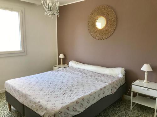 - une chambre avec un lit, deux tables et un miroir dans l'établissement Grand appartement proche mer avec WIFI, au Lavandou