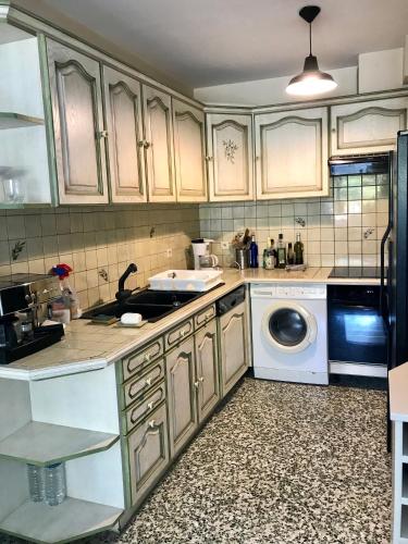 une cuisine avec un évier et une machine à laver dans l'établissement Grand appartement proche mer avec WIFI, au Lavandou