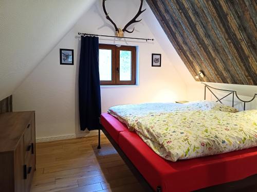 a bedroom with a bed and a window at Kuckucksnest - Nid de Coucou in Sondernach