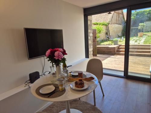 un salon avec une table avec un vase de fleurs dans l'établissement Maison Floréal Giverny, à Giverny