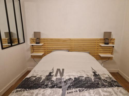une chambre avec un lit avec un panneau dessus dans l'établissement 2 pièces hyper centre de La Rochelle, proche du port et de la plage, à La Rochelle