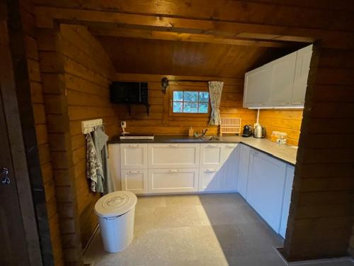a kitchen with white cabinets and a trash can at Het Horste Huisje in Enschede