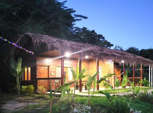 a small house with a thatched roof at Promisedland Tayrona Cabins Hotel in Buritaca