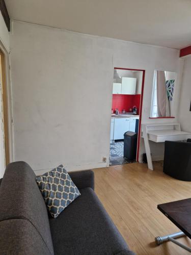 un salon avec un canapé et une cuisine dans l'établissement 2 pièces hyper centre de La Rochelle, proche du port et de la plage, à La Rochelle