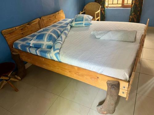 a bed with a wooden frame in a room at Kivu Beach Garden in Gisenyi