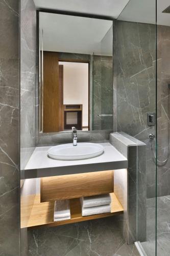a bathroom with a sink and a mirror at Le Meridien Hyderabad in Hyderabad