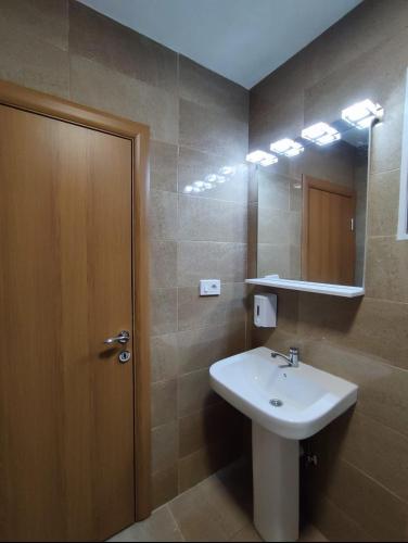 a bathroom with a sink and a mirror at Vila Ideal New in Donji Štoj