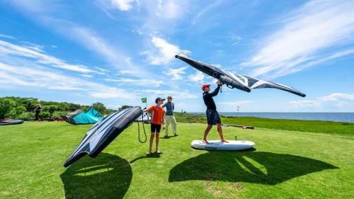 a group of people standing on a field with a plane on a slide at Watermen's Cabana 1B - 2-Bed, 1-Bath Apartment - Walk To BEACH Access & PET Friendly! in Waves