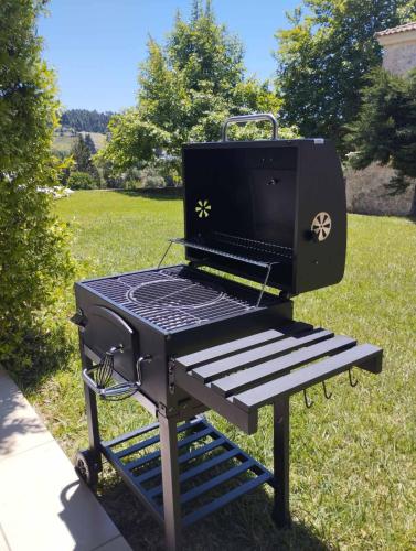a bbq grill sitting on a bench in the grass at Siviri Traditional Stone House in Siviri
