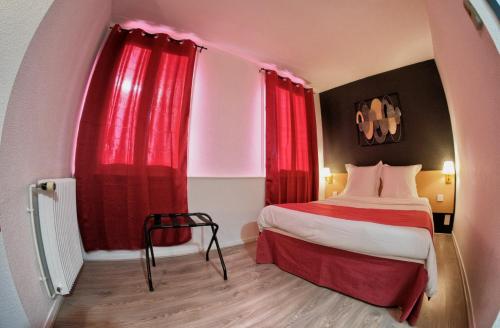 a hotel room with a bed with red curtains at Hotel Le Gambetta in Bergerac
