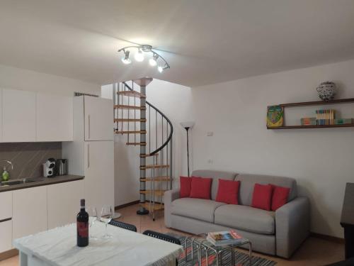 un salon avec un canapé et un escalier en colimaçon dans l'établissement Casa Carolina, à Montagna in Valtellina