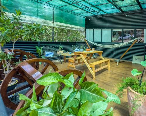 a patio with a hammock and tables and plants at Petra Lago in San Bernardino
