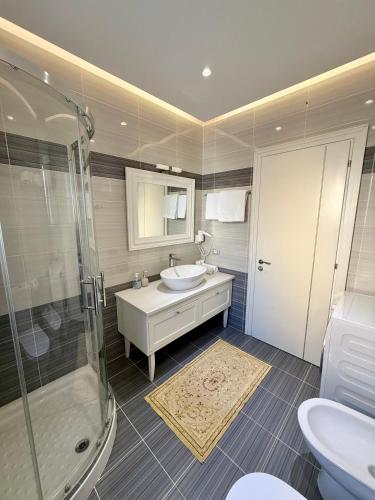 a bathroom with a sink and a shower at Limani Deluxe Apartments in Sarandë