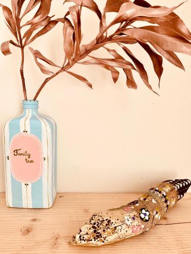 a glass bottle with a plant in it next to a wand at Family Tree - WATER Available - SELF check in in Golem