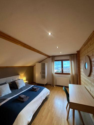 a bedroom with a bed and a table and a window at Chalet 3 Vallées - Piscine & SPA - Haut Standing in Rupt-sur-Moselle