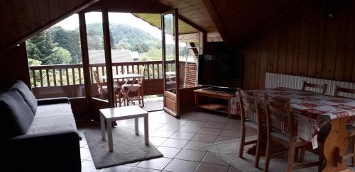 un salon avec une table et une télévision sur un balcon dans l'établissement Bel appartement 80m2, à Venthon