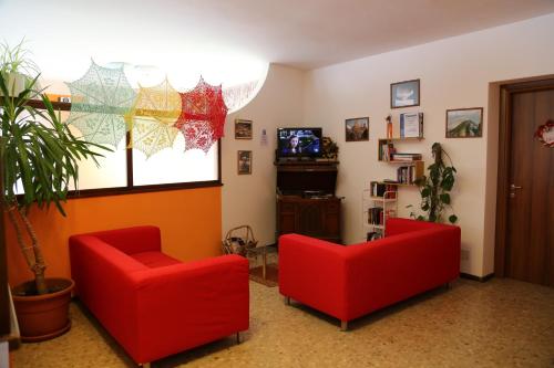 a living room with two red chairs and a tv at Da Cecilia in Bognanco