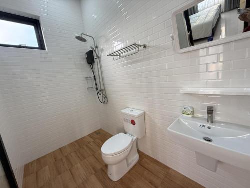 a white bathroom with a toilet and a sink at Baan Santi in Koh Phangan in Thongsala