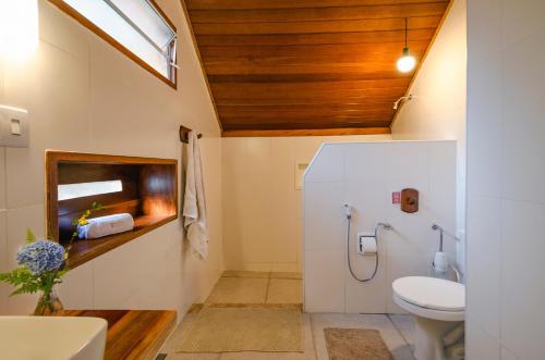 a bathroom with a toilet and a sink at Pousada Colher de Chá - chalés in Visconde De Maua