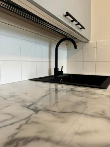 a kitchen with a sink and a marble floor at Lägenhet Kaskö in Kaskö