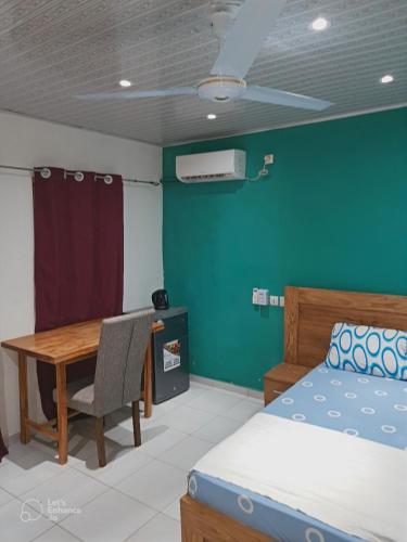 a bedroom with a bed and a desk and a table at La Résidence in Lomé