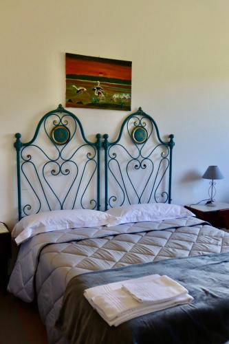 a bedroom with a bed with a blue metal headboard at Casa Lux Mundi Lucca in Lucca
