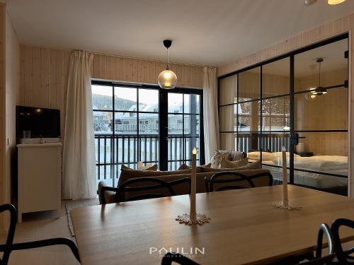 a living room with a table and a bedroom at Lindvallen Ski Resort Pool and Padel - Sauna - 4 Guests in Sälen