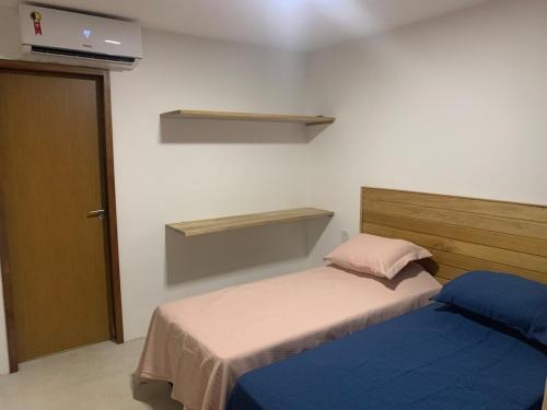 a small bedroom with two beds and a door at Sunset Patacho in Pôrto de Pedras