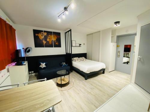 une petite pièce avec un lit et une table dans l'établissement Quai 86 - Studio, clim mobile, parking, proche gare & centre, à Poitiers