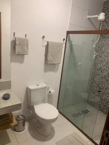 a bathroom with a toilet and a glass shower at Sunset Patacho in Pôrto de Pedras