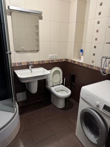 a bathroom with a toilet and a sink and a washing machine at Отдых у моря Одесса in Kryzhanivka