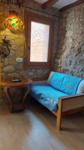 a bed in a room with a table and a window at Cal Mitger in Viñaixa