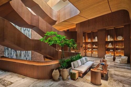 a lobby with a couch and tables and a staircase at The St. Regis Cap Cana Resort in Punta Cana