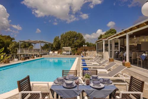 a patio with tables and chairs next to a pool at Panorama Fanari studios and apartments in Argostoli