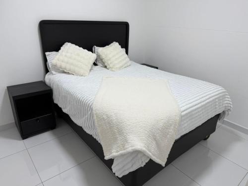 a white bed with white sheets and pillows on it at 268 Self-catering Apartments in Swakopmund