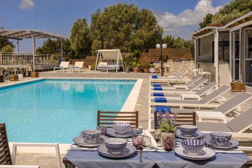 a pool with a table with blue and white dishes on it at Panorama Fanari studios and apartments in Argostoli