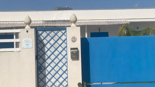 a blue front door of a house with a gate at Casa Vacanze-Le stanze di Eolo in Marsala