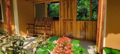 a porch with a chair and a plant with flowers at Tayrona Farm House Sleep 15 AC Breakfast included in Buritaca