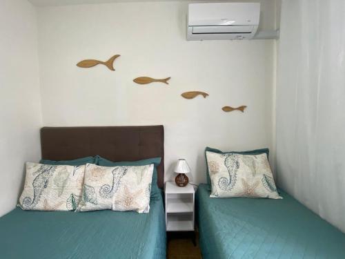 duas camas num quarto com pássaros na parede em Ap 100 mtrs da praia do forte em Cabo Frio