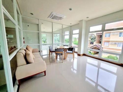 a living room with a couch and a table and windows at Vista Manors Verdant Palawan in Puerto Princesa