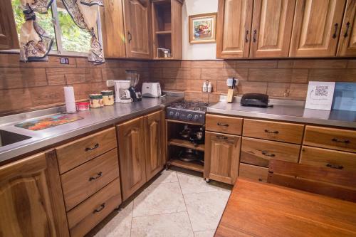 a kitchen with wooden cabinets and a stove top oven at Tayrona Farm House Sleep 15 AC Breakfast included in Buritaca