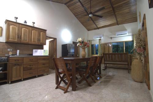 a kitchen with a wooden table and chairs and a kitchen with at Tayrona Farm House Sleep 15 AC Breakfast included in Buritaca