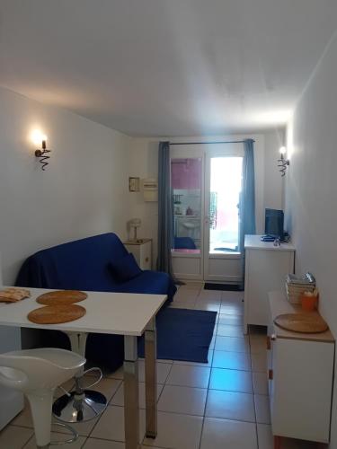 un salon avec un canapé bleu et une table dans l'établissement Le studio, à Cavaillon