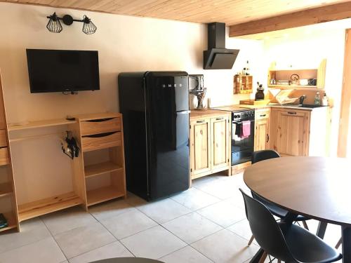 a kitchen with a black refrigerator and a table at Les chardons bleus in Formiguères